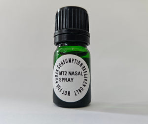 Small green spray bottle with a black label on a light gray background
